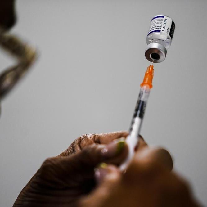 A syringe is prepared with the Pfizer COVID-19 vaccine.jpeg